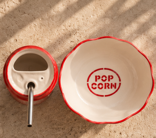 Top view of Coca-Cola tumbler and popcorn bowl showing straw opening and bowl interior