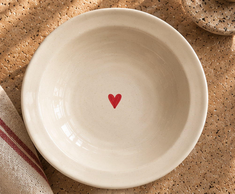 Top view of cream pasta plate with red heart detail